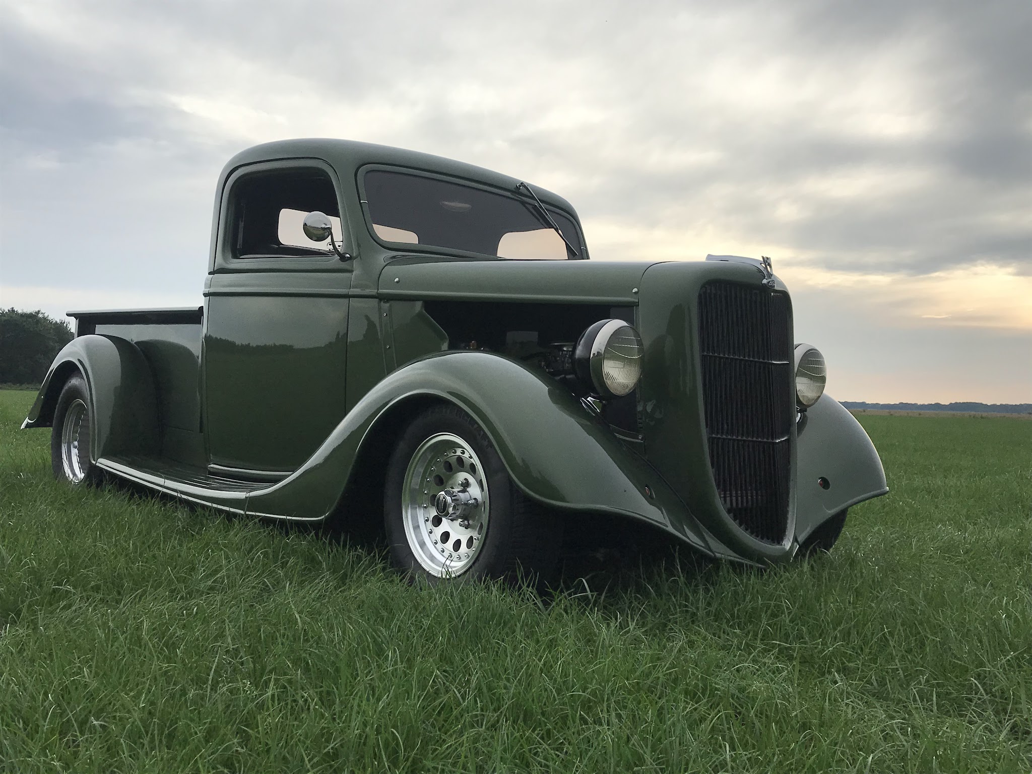 Groene klassieke Amerikaanse pickup in het landschap